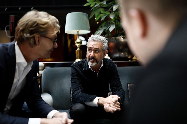 Tre män som sitter och pratar