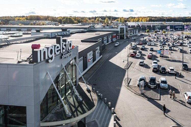 Utsidan av ett shoppingcenter och parkeringen