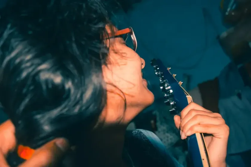 Kvinna spelar på gitarr