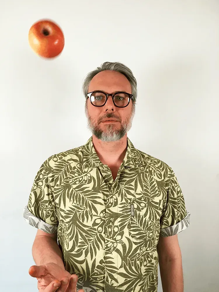 En man som länger upp ett äpple i luften