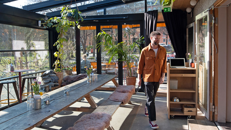 En man I orange skjorta i uterum till en restaurang