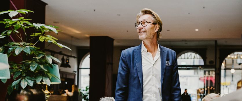 En man med glasögon och blå kavaj