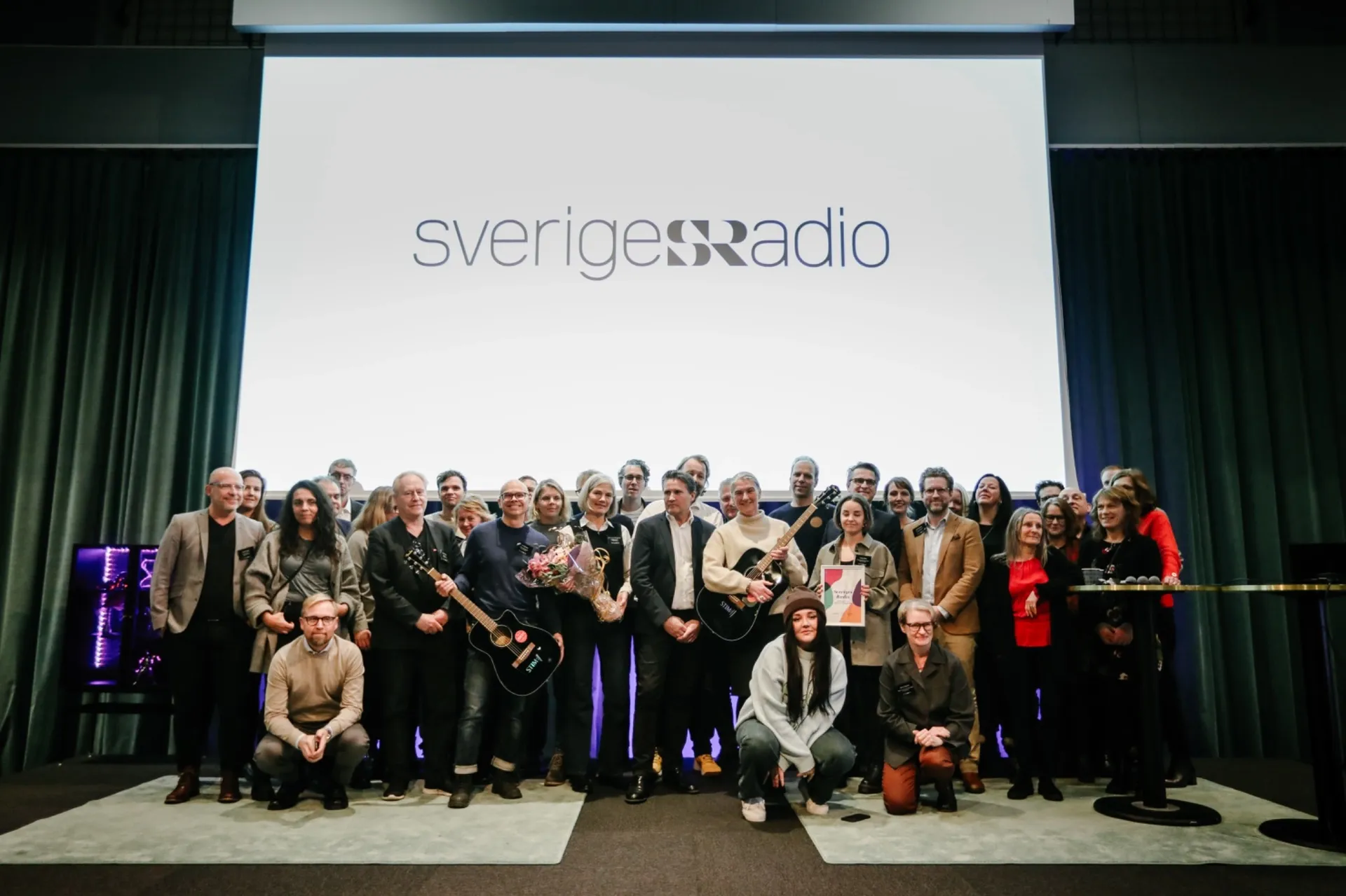 Gruppbild på musikredaktörer på Sveriges Radio tillsammans med upphovspersonen Bell och Director of Marketing and Members Peter Lindström