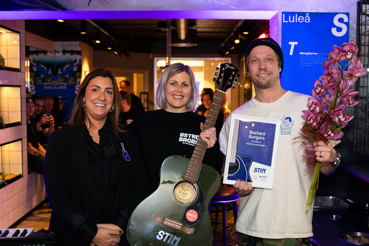 Adina Broström (Head og General Licensing delar ut Stimgitarren till Bastard Burgers grundare och VD Simon Wanler och Malin Hansegård (Head of New Business and Local Marketing)