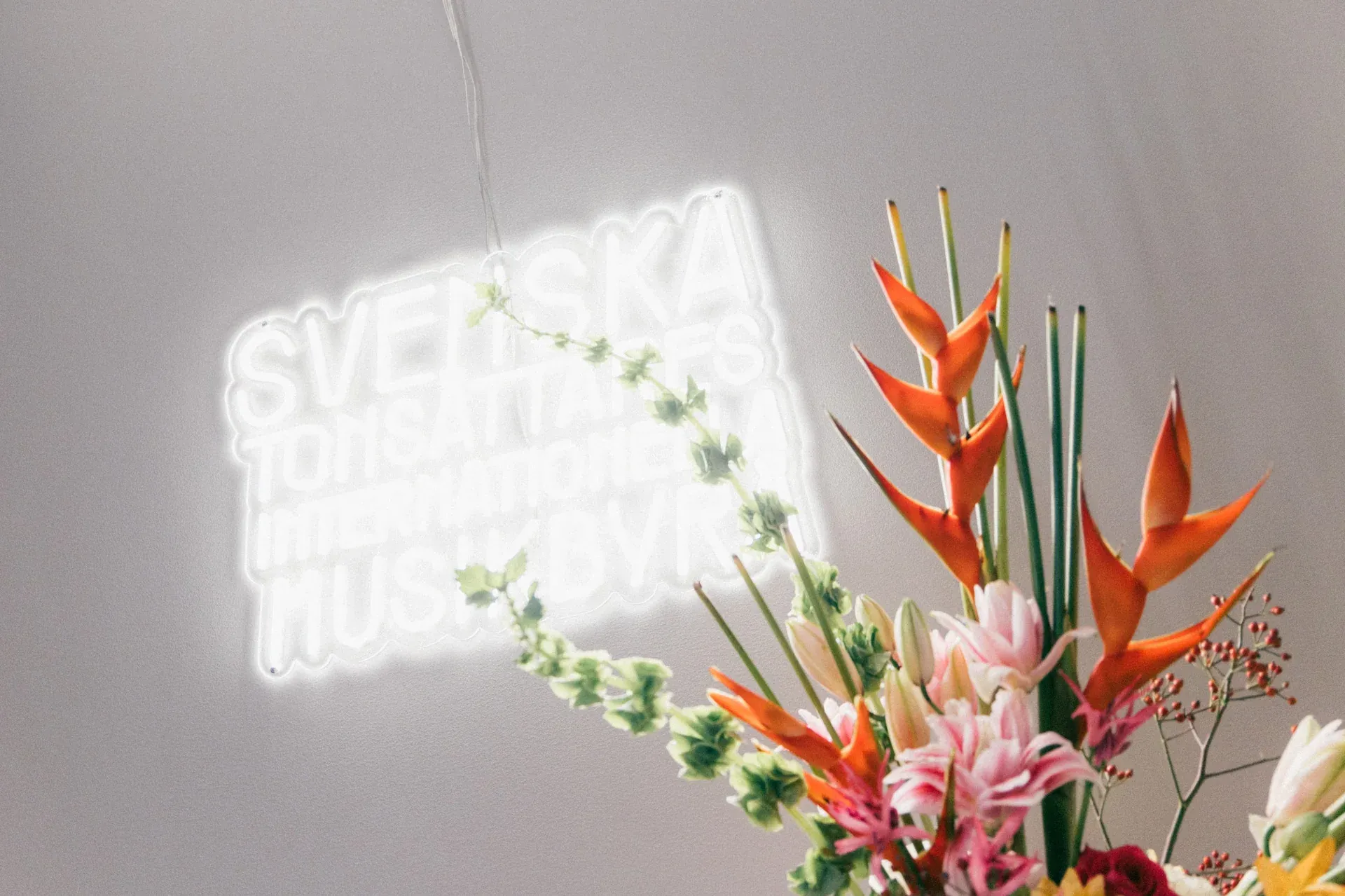 Blombukett framför Stim-neonskylt